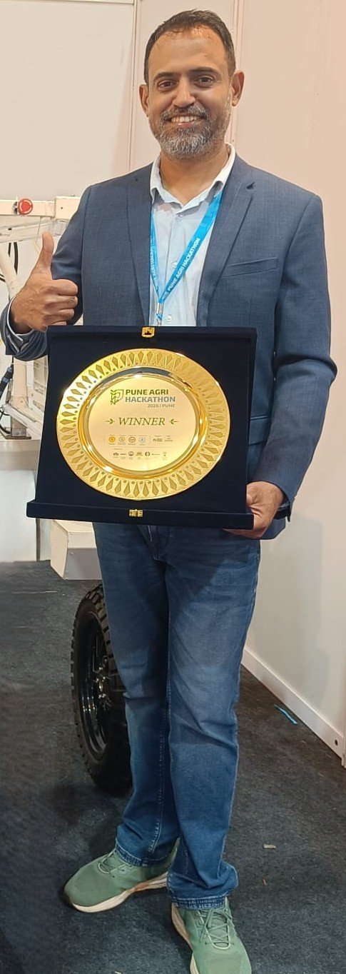 Dr. Ajit Nehe holding the Pune Agri Hackathon winner's plate